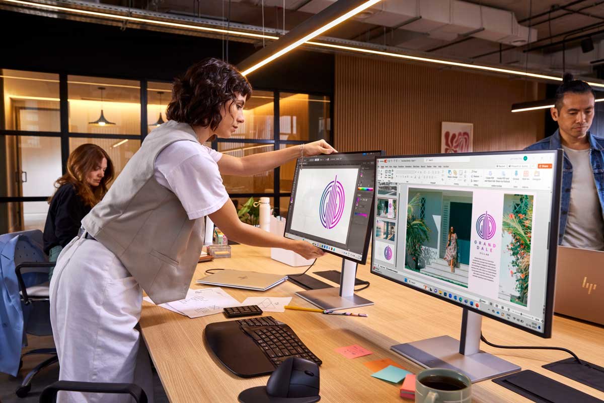 Woman working on a curved monitor in an office setting.