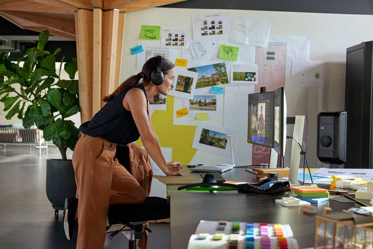Woman working on a curved monitor in an office setting.